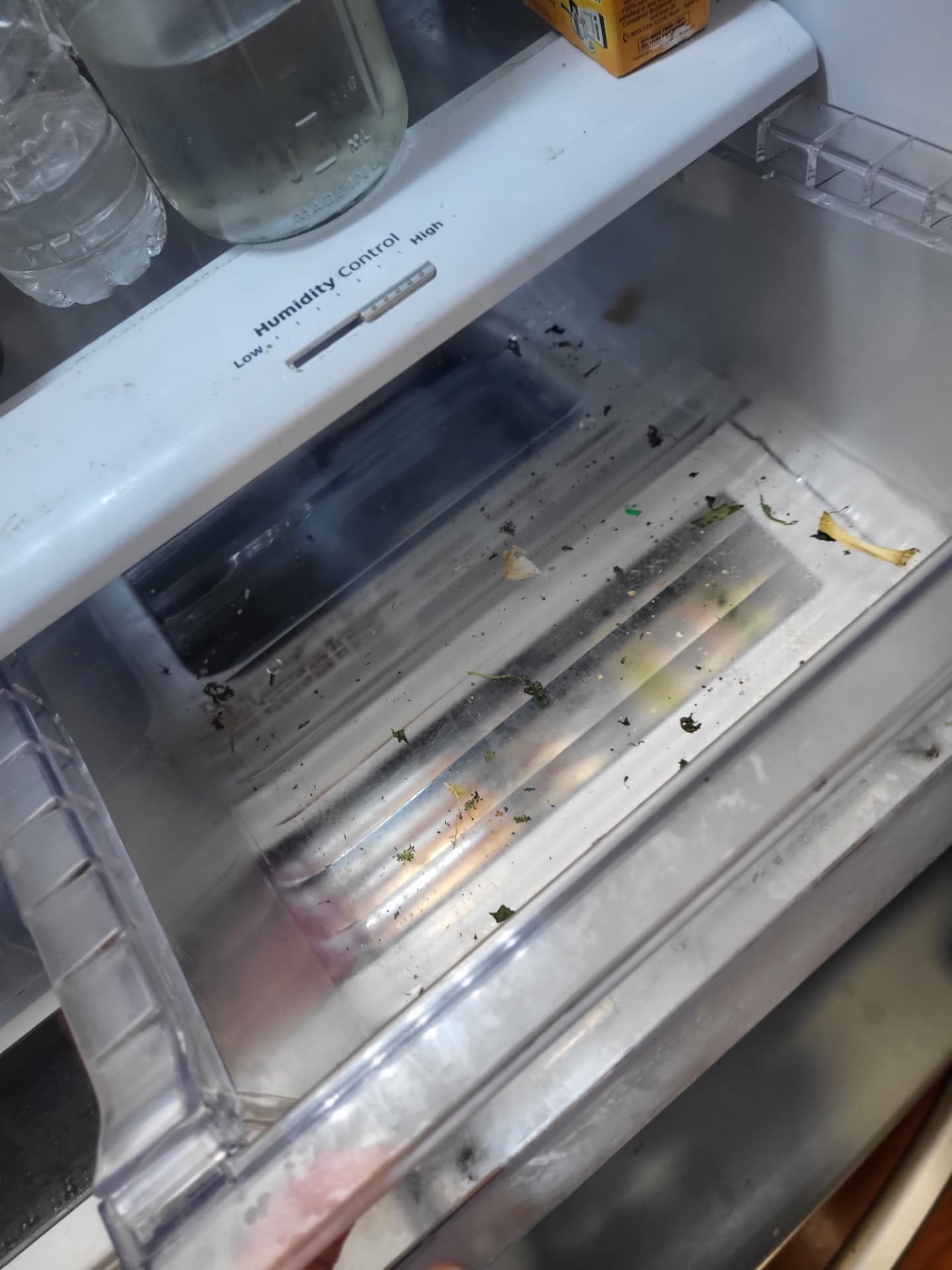 Dirty refrigerator drawer with crumbs and debris before a Meraki Clean deep clean
